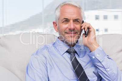 Cheerful businessman calling on smartphone