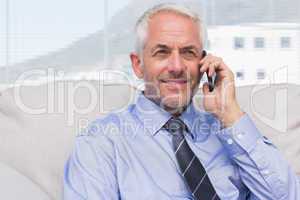 Cheerful businessman calling on smartphone