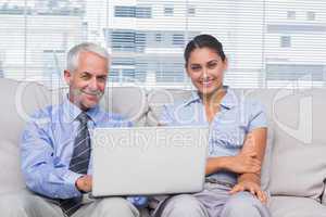 Business people with laptop smiling at camera
