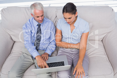 Business people using laptop on the couch
