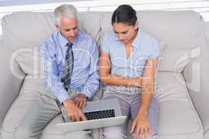 Business people using laptop on the couch