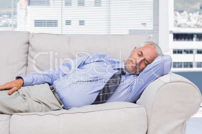 Businessman lying on sofa asleep
