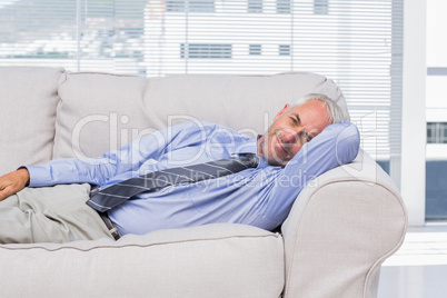 Businessman lying on sofa resting