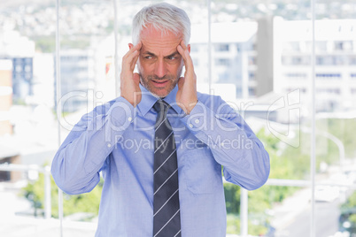 Stressed businessman rubbing his temples