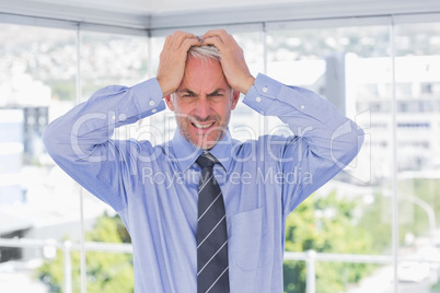 Frustrated businessman with hands on his head