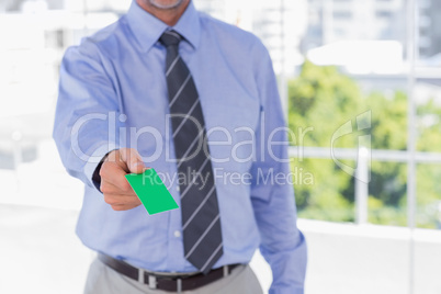 Businessman offering green business card