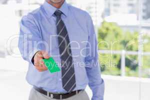 Businessman offering green business card