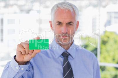 Businessman showing green business card