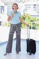 Businesswoman with coffee and suitcase