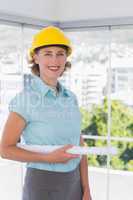 Architect looking at camera with helmet and blueprint