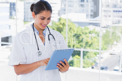 Smiling young doctor using tablet pc