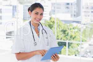 Happy young doctor using tablet pc