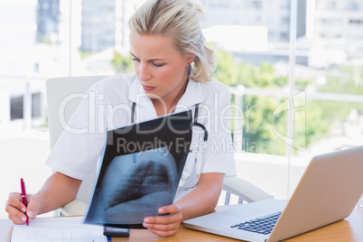 Nurse holding an x ray in her office