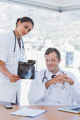 Attractive doctor showing a x ray to a colleague