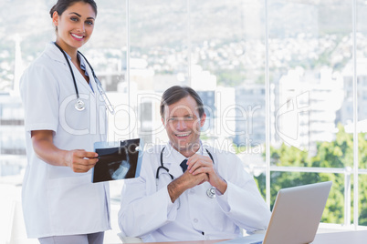 Smiling group of doctors working on a x ray