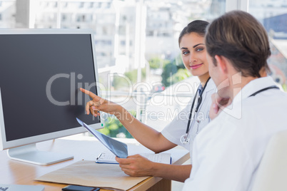 Doctor showing the screen of a computer to a colleague