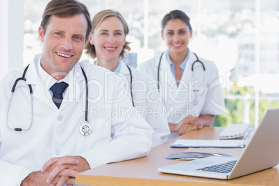 Happy group of doctors posing at their desk
