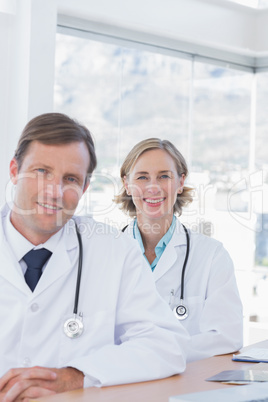 Smiling group of doctors posing at their desk