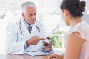 Doctor explaining the bottle of pills to patient