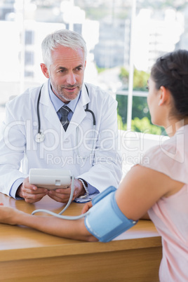 Doctor taking heartbeat of a female patient