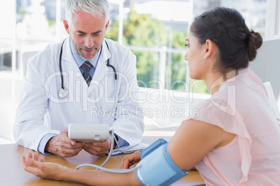 Doctor measuring blood pressure of a patient