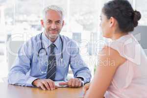 Attractive doctor sitting in front of patient