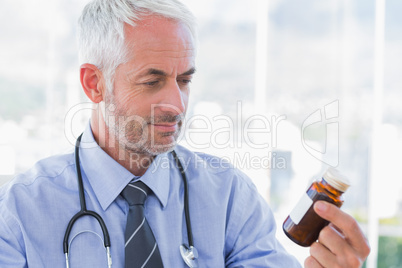 Doctor looking at medicine jar Doctor looking at medicine jar