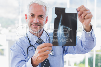 Smiling doctor holding a radiography