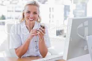 Smiling nurse sitting behind a desk