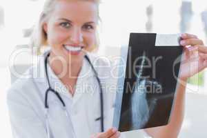 Cheerful nurse holding an x-ray