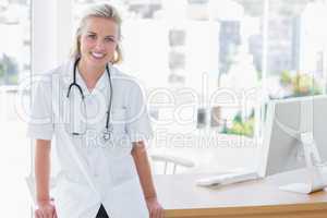 Attractive nurse leaning on desk