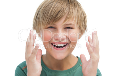 Suprised blonde boy with hands up smiling