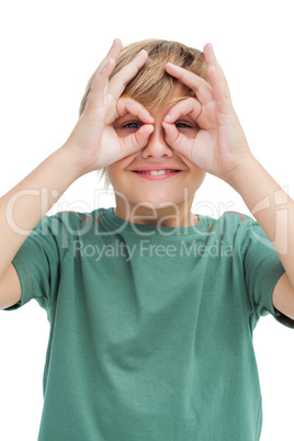 Happy little guy making goggles with his fingers