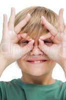 Happy little boy making goggles with his fingers