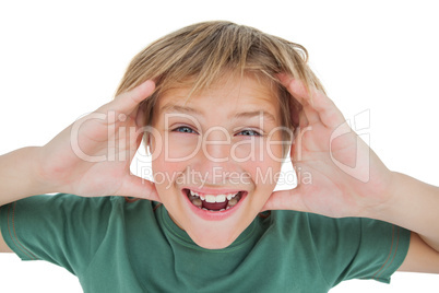 Amazed boy smiling with hands raised