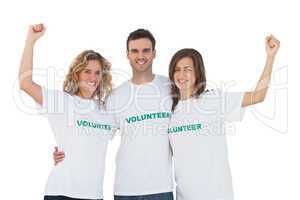 Smiling group of volunteers raising arms
