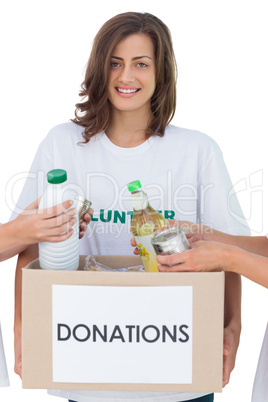 Smiling volunteer holding a food donation box