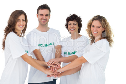 Smiling volunteer group piling up their hands