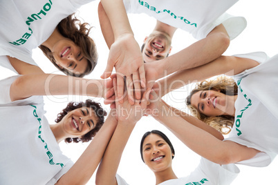 Cheerful group of volunteers putting hands together