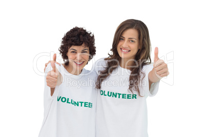 Two smiling volunteers giving thumbs up Two smiling volunteers giving thumbs up
