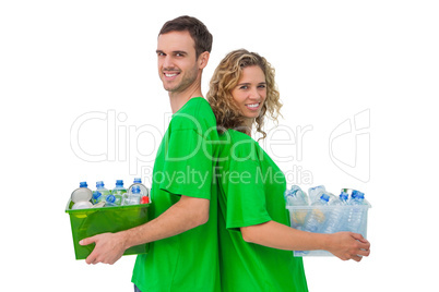 Two smiling activists holding box of recyclables and standing ba