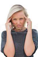 Woman with headache touching her forehead and looking at camera