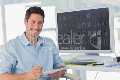 Handsome photo editor holding documents