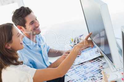 Photo editors pointing at a computer screen