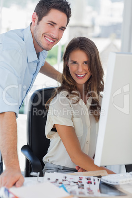 Happy photo editors working together on a computer