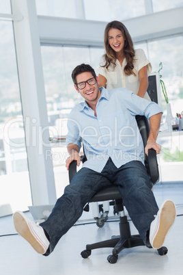 Happy designers having fun with a swivel chair