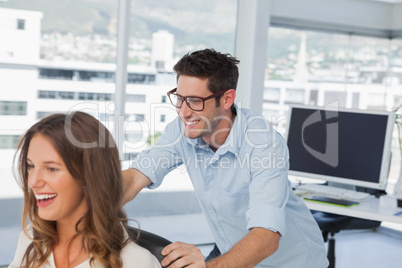 Smiling designers playing on a swivel chair