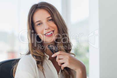 Businesswoman posing while she is holding her reading glasses
