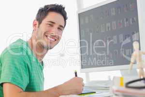 Cheerful photo editor working on graphics tablet