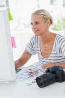 Cheerful photo editor working at her desk